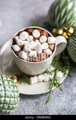 Top view of delicious cocoa with marshmallow on plate with fir twigs placed near Christmas balls Stock Photo