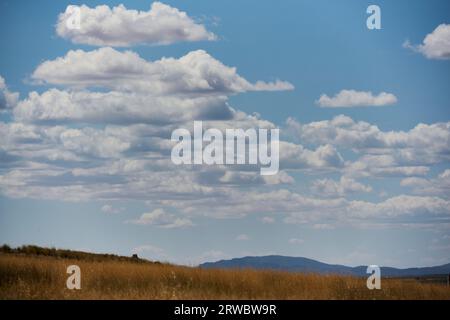 From below of of a sky with clouds overcast above green hills in blurred background Stock Photo