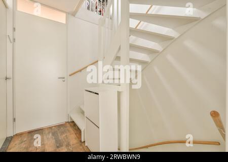 White stairway located by room with closed door in minimalist styled corridor in modern house Stock Photo