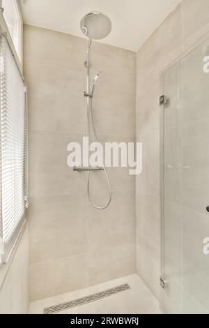 Interior of modern shower cabin with glass door and window with chrome faucet on tiled wall in elegant bathroom Stock Photo