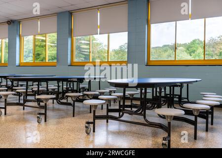 Blue folding table with attached seats in a school cafeteria. Stock Photo