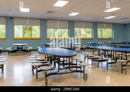 Blue folding table with attached seats in a school cafeteria. Stock Photo