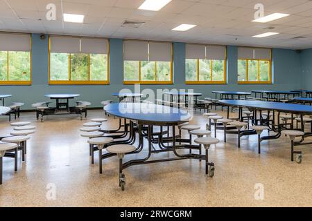 Blue folding table with attached seats in a school cafeteria. Stock Photo