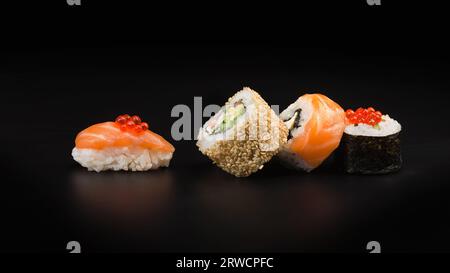 Sushi with red caviar on a black table. Macro close up. Stock Photo