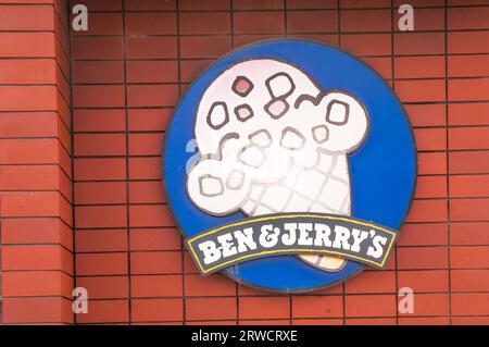 Ben and Jerrys large ice cream motif sign set against red stackbond brickwork on side of building Stock Photo
