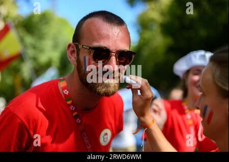 A French pilgrim – a young man – having his cheeks painted with French national colours during World Youth Days in Lisbon, Portugal. Stock Photo
