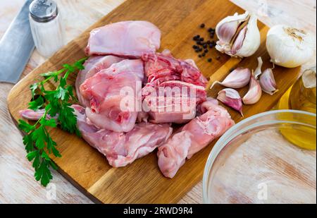 Delicious cutting rabbit meat with spices and herbs on kitchen board Stock Photo