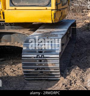 Closeup of an aged and worn steel track on an older used but working excavator. Stock Photo