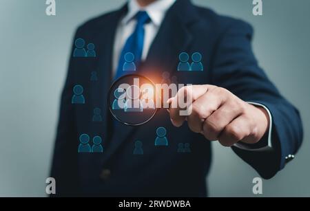 Business people use a magnifying glass to find business target groups,Target customer, Buyer persona, Customer behavior concept. Marketing plan and st Stock Photo