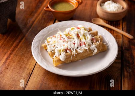 Tacos Dorados. Mexican dish also known as Flautas, consists of a rolled corn tortilla with some filling, commonly chicken or beef or vegetarian option Stock Photo