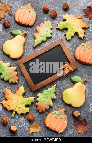 Multicolored autumn homemade cookies and empty blackboard on dark background. Stock Photo