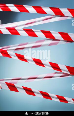 Red and white plastic barrier tape blocking the way Stock Photo