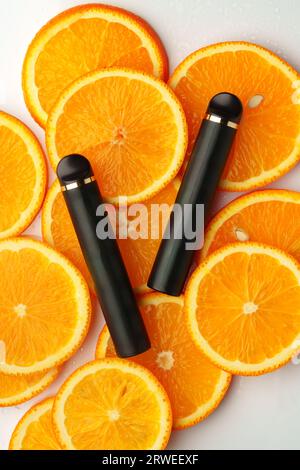 Two electronic cigarettes on orange pieces stacked on white background Stock Photo