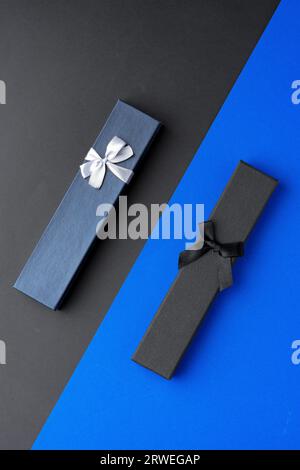Two long jewelry boxes on black and blue background Stock Photo