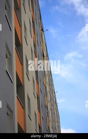 Slab building in different colours, detail, background blue sky and white clouds Stock Photo