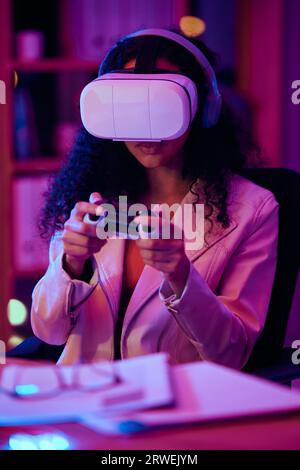 Virtual reality, glasses and woman, gaming developer or programmer for game software and futuristic electronics at night. Information technology gamer Stock Photo