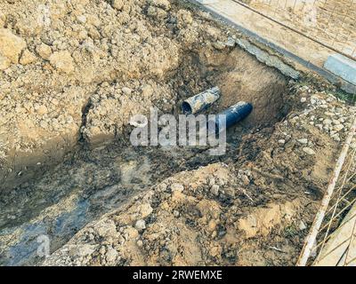 sandy ditch with communications. in a new microdistrict of the city, pipes are being laid to bring communications to residential buildings. draining w Stock Photo