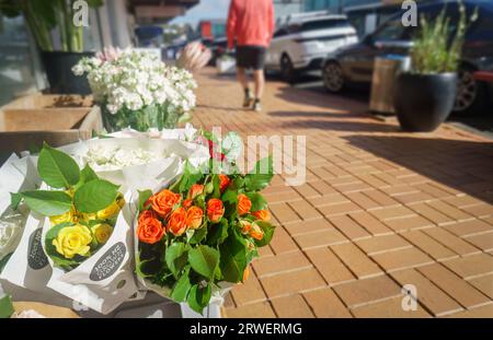 Beautiful flowers on display outside the flower shop. “100% NZ Grown Flowers” printed on the paper bags. Buy NZ made concept. Stock Photo