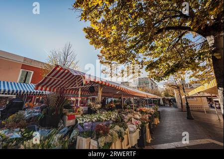 Nice, France - 11 19, 2016  Famous flower market featuring fresh cut flowers in central Place Charles Félix. Kiosks or stalls selling blooming flowers Stock Photo
