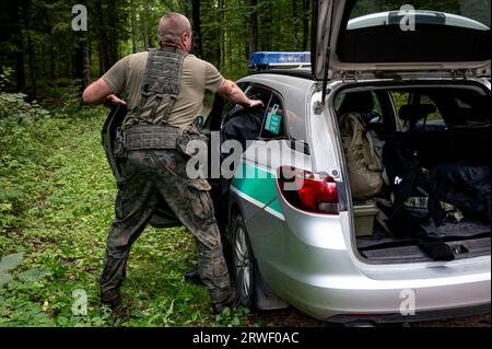 PRODUCTION - 06 September 2023, Poland, Hajnowka: A Polish border guard arrests a man in the border area with Belarus. On the EU's external border with neighboring Belarus, Poland has erected a 5.5-meter-high metal fence with motion detectors and night-vision cameras. Poland and the EU Commission accuse Belarusian ruler Lukashenko of systematically bringing migrants from crisis regions to the border. The border region is guarded martially: In addition to the 5,000 border guards and 500 police officers, 4,000 soldiers are deployed, with another 6,000 in reserve. Human rights organizations compl Stock Photo