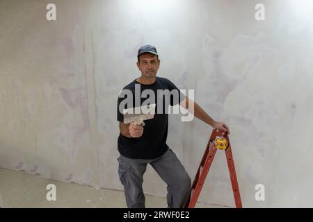 Male builder, master office, plasterer with a tool in working clothes Stock Photo