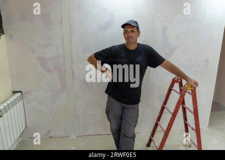 Male builder, master office, plasterer with a tool in working clothes Stock Photo