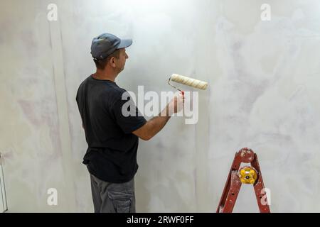 Male builder, master office, plasterer with a tool in working clothes Stock Photo