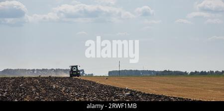 Agricultural tractor plowing a field before sowing. Stock Photo