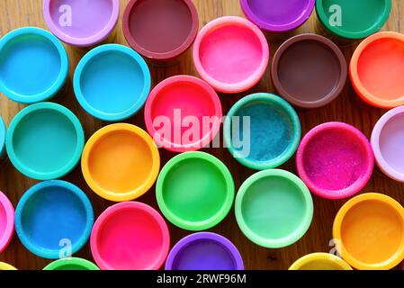 A colourful circular pattern created by multi coloured plastic tops arranged into an abstract image Stock Photo