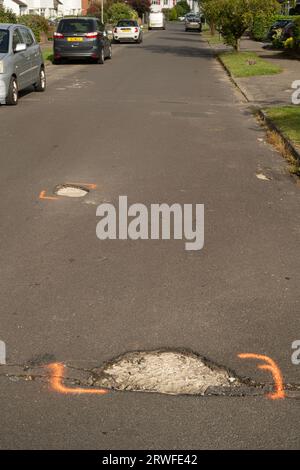 Potholes in suburban road. Surrey, UK Stock Photo