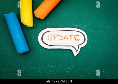 UPDATE Concept. Speech bubble on a green chalkboard background. Stock Photo