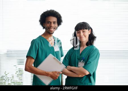 Portrait of medical nurses in green scrubs smiling at camera Stock Photo