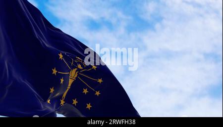 Close-up of indiana state flag waving in the wind on a clear day. Golden torch surrounded by nineteen stars in a dark blue area. 3d illustration rende Stock Photo