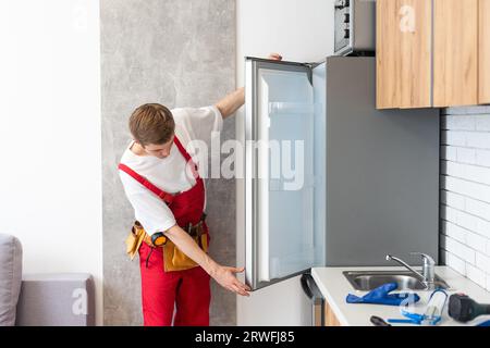 Electrician Technician Working To Repair Refrigerator Or Fridge Appliance Stock Photo