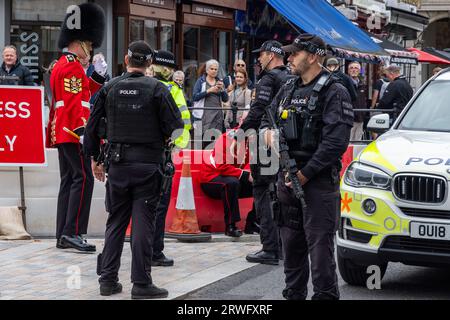 Windsor, UK. 19th September, 2023. Police officers tend to an injured Grenadier guardsman during the Changing of the Guard ceremony in Windsor High Street. According to a ceremonial warden present at the scene, the Guardsman slipped and cut himself while marching to Windsor Castle. Credit: Mark Kerrison/Alamy Live News Stock Photo