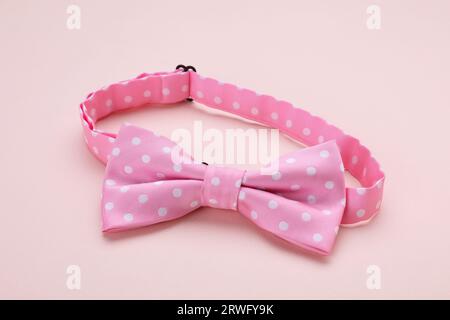Stylish pink bow tie with polka dot pattern on beige background Stock Photo