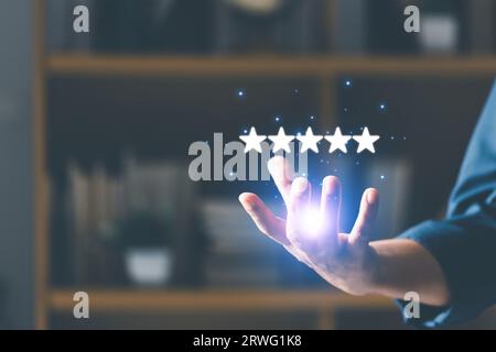 User give rating to service experience on online application for Customer review satisfaction feedback survey concept. Businesswoman holding five star Stock Photo