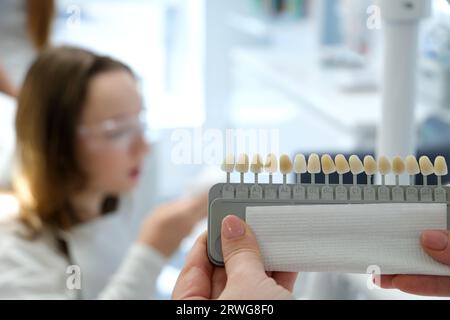 tooth whitening, perfect white crown teeth close up with shade guide bleach color, female veneer smile, dental care and stomatology, dentistry, copyspace. Stock Photo