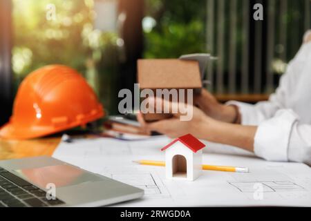 Close up of house model on architect female holding house model background. Stock Photo