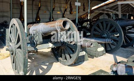 Bangkok, Thailand, December 27, 2018. A collection of old, rusted cannons on wooden carriages, displayed in a row in a museum. Stock Photo