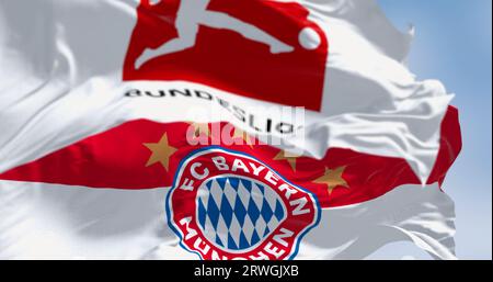 Munich, DE, Sept 10 2023: Bayern Munich flag waving with Bundesliga flag on a clear day. Professional german football club. Illustrative editorial 3d Stock Photo