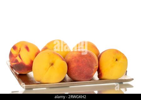 Several ripe peaches on a metal tray, macro, isolated on white background. Stock Photo