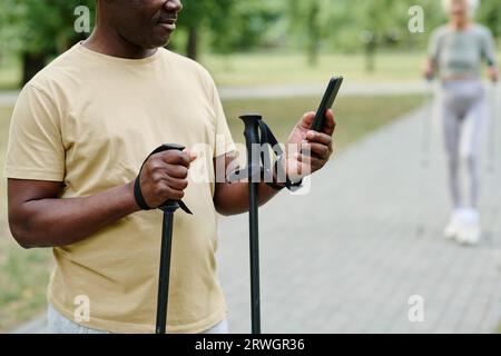 Close-up of African American senior man using mobile phone during training outdoors Stock Photo