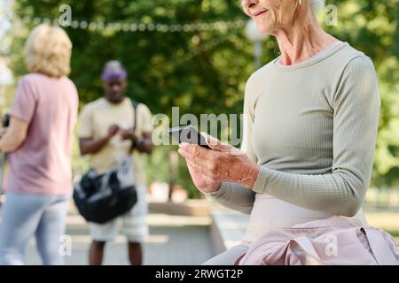 Close-up of senior woman using smartphone after sport training outdoors Stock Photo