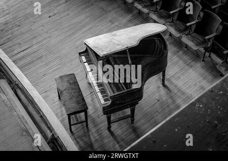 A grand piano in an abandoned school auditorium Stock Photo