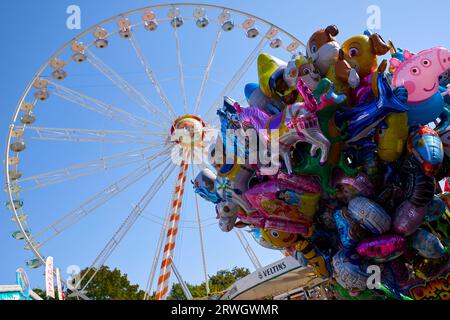 Arnsberg, NRW, Germany - 09 10 2023, Ferris wheel at a funfair, colorful baloons in the foreground Stock Photo