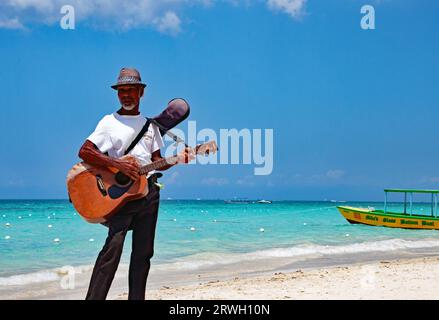 A Jamaican man playing guitar on the Seven Mile Beach in Negril Jamaica Stock Photo