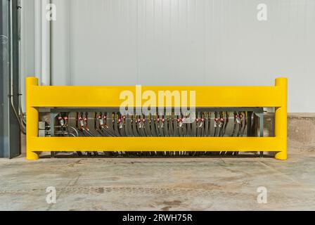 Yellow guard rail and piping for floor warming on loading dock in a newly constructed industrial refrigeration (cold-storage) facility loading dock. Stock Photo