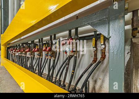 Yellow guard rail and piping for floor warming on loading dock in a newly constructed industrial refrigeration (cold-storage) facility loading dock. Stock Photo