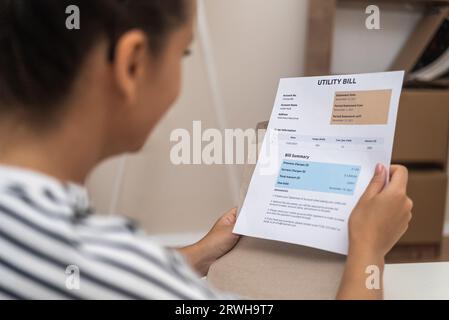 close-up woman reading utility bills and online payments through modern technology. Stock Photo